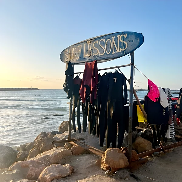 École de surf face à l’océan, combinaisons au séchage