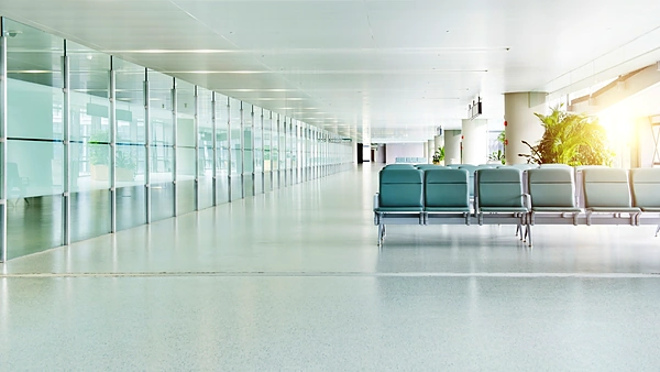 Hall d’aéroport moderne et lumineux, rangée de sièges le long des baies vitrées