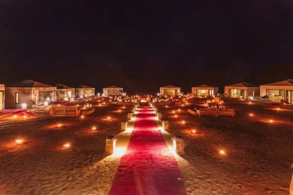 Path of lanterns and red carpet in the desert at night