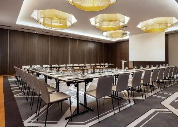 Seminar room with U-shaped tables, gilded chandeliers and wood panelling, Rabat