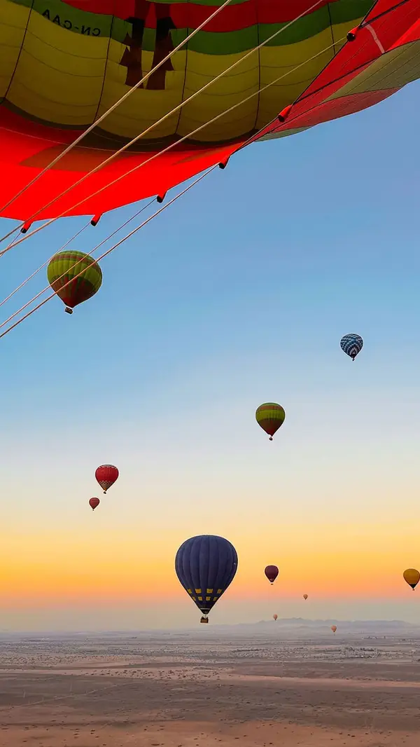 Hot-air balloons at sunrise above the desert